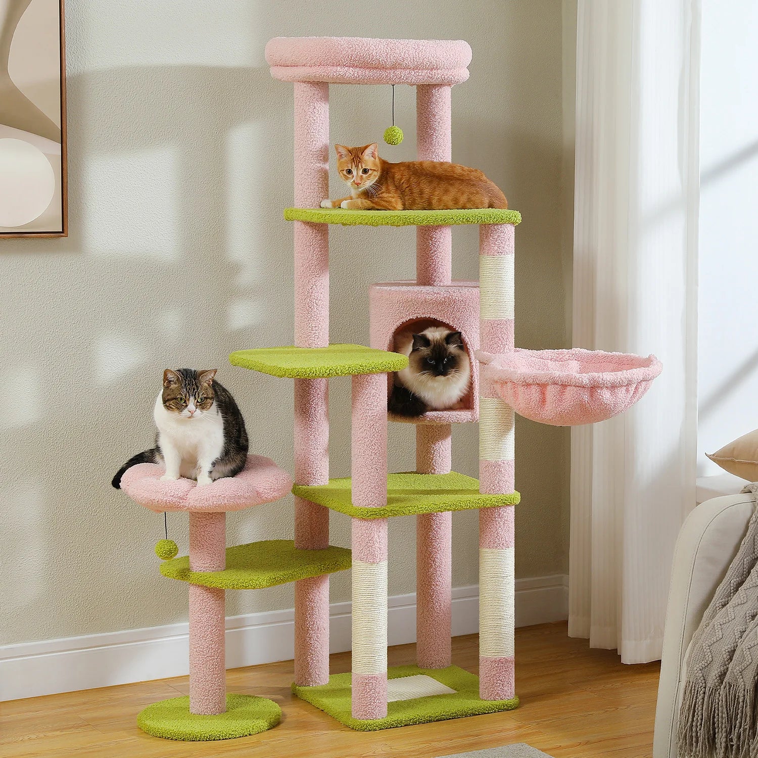 Pink and green cat tree with cats on various levels in a room.