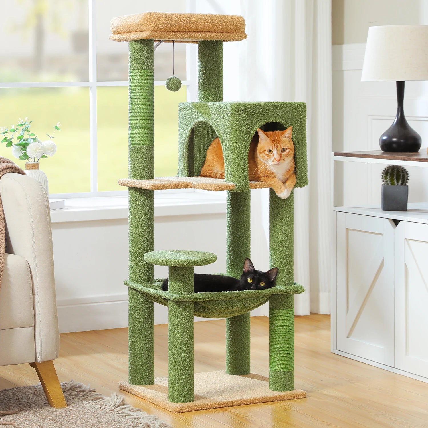 Green cat tree with two cats in a living room setting