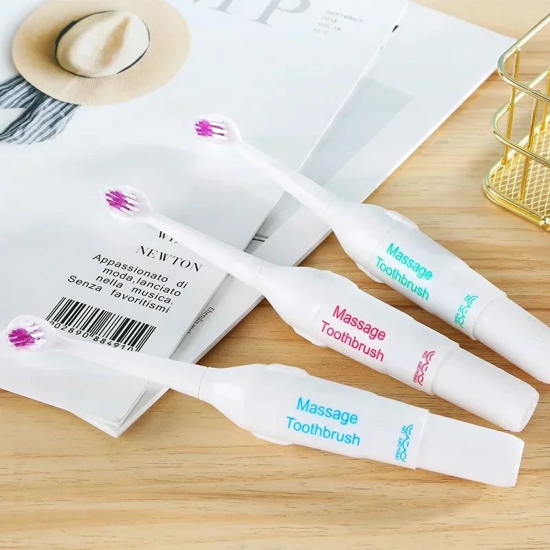 Massage Toothbrushes on a wooden surface with a magazine and hat in the background
