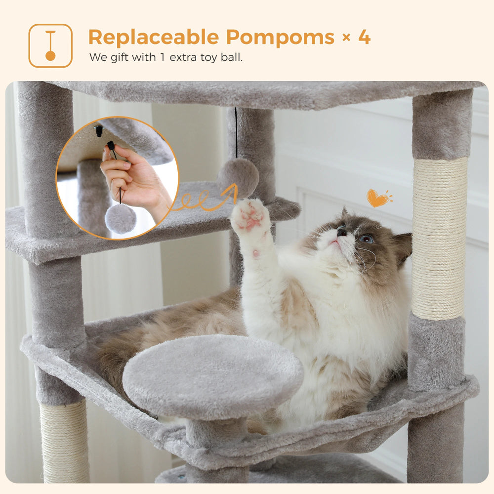 Cat playing with a gray cat tree with replaceable pom-poms, featuring a hand holding a pom-pom.