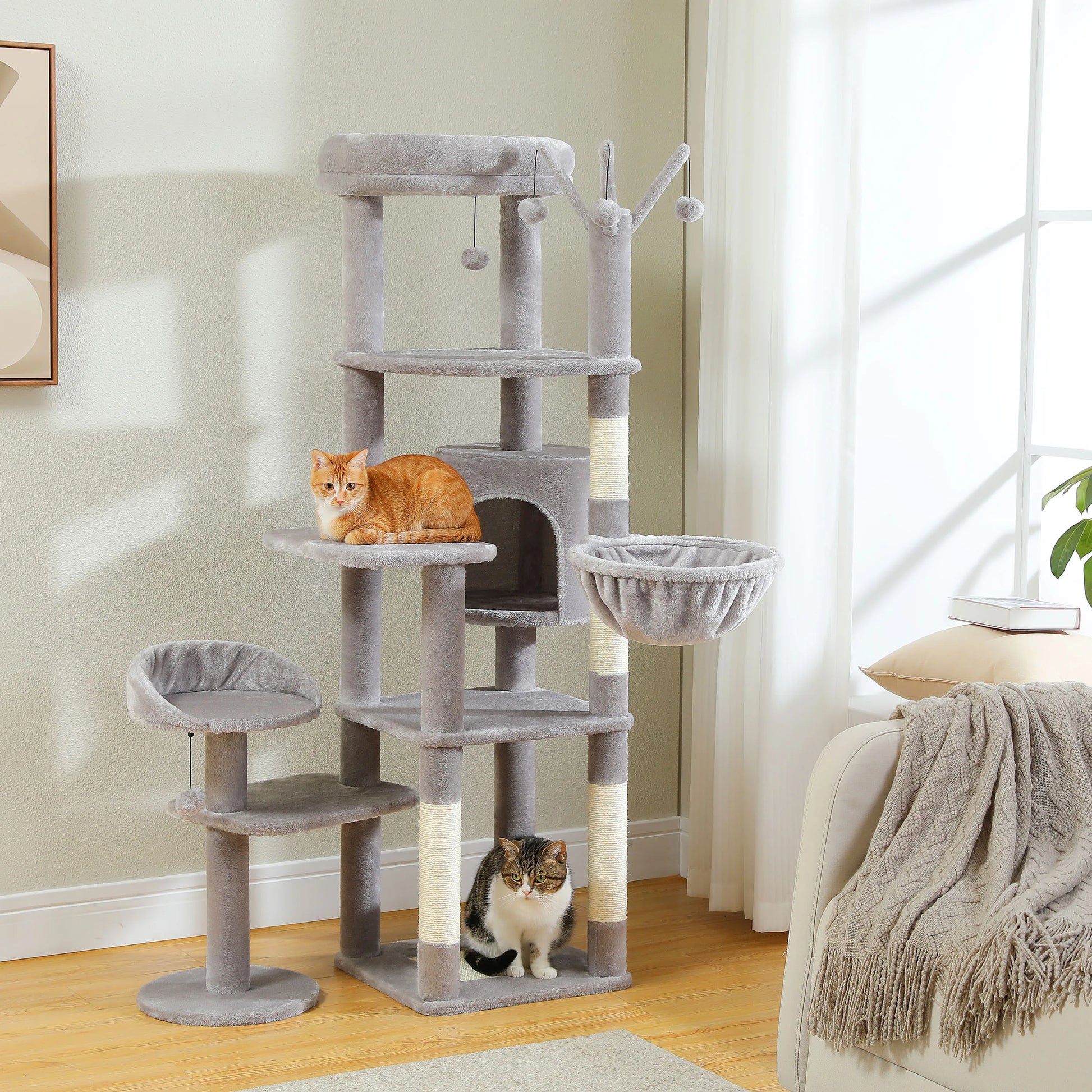 Cat tree with multiple levels and a cat sitting on one of the platforms in a room.